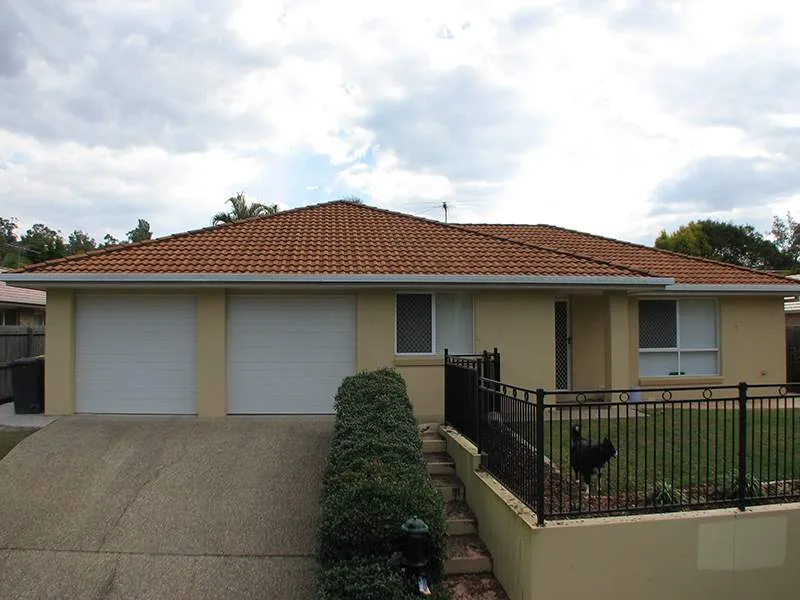 A house with a red tile roof and white garage doors