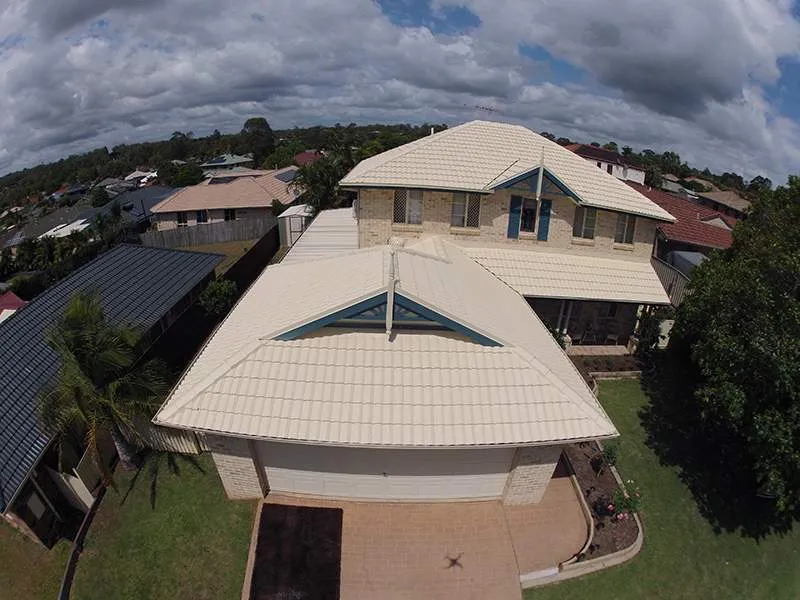 An aerial view of a house with a white roof