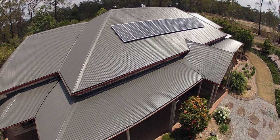 An aerial view of a house with solar panels on the roof.