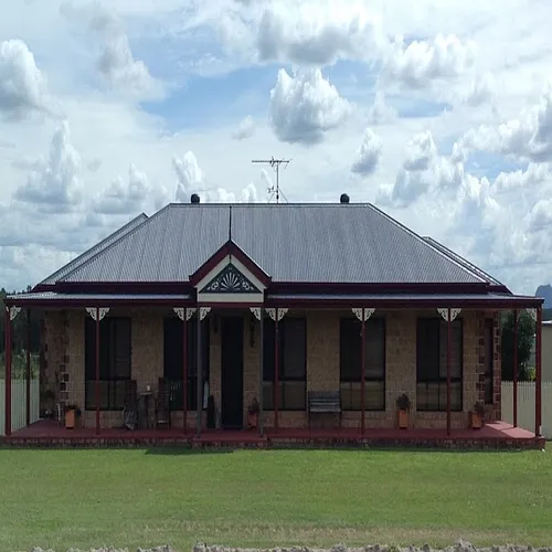 A large house with a porch and an antenna on top of it