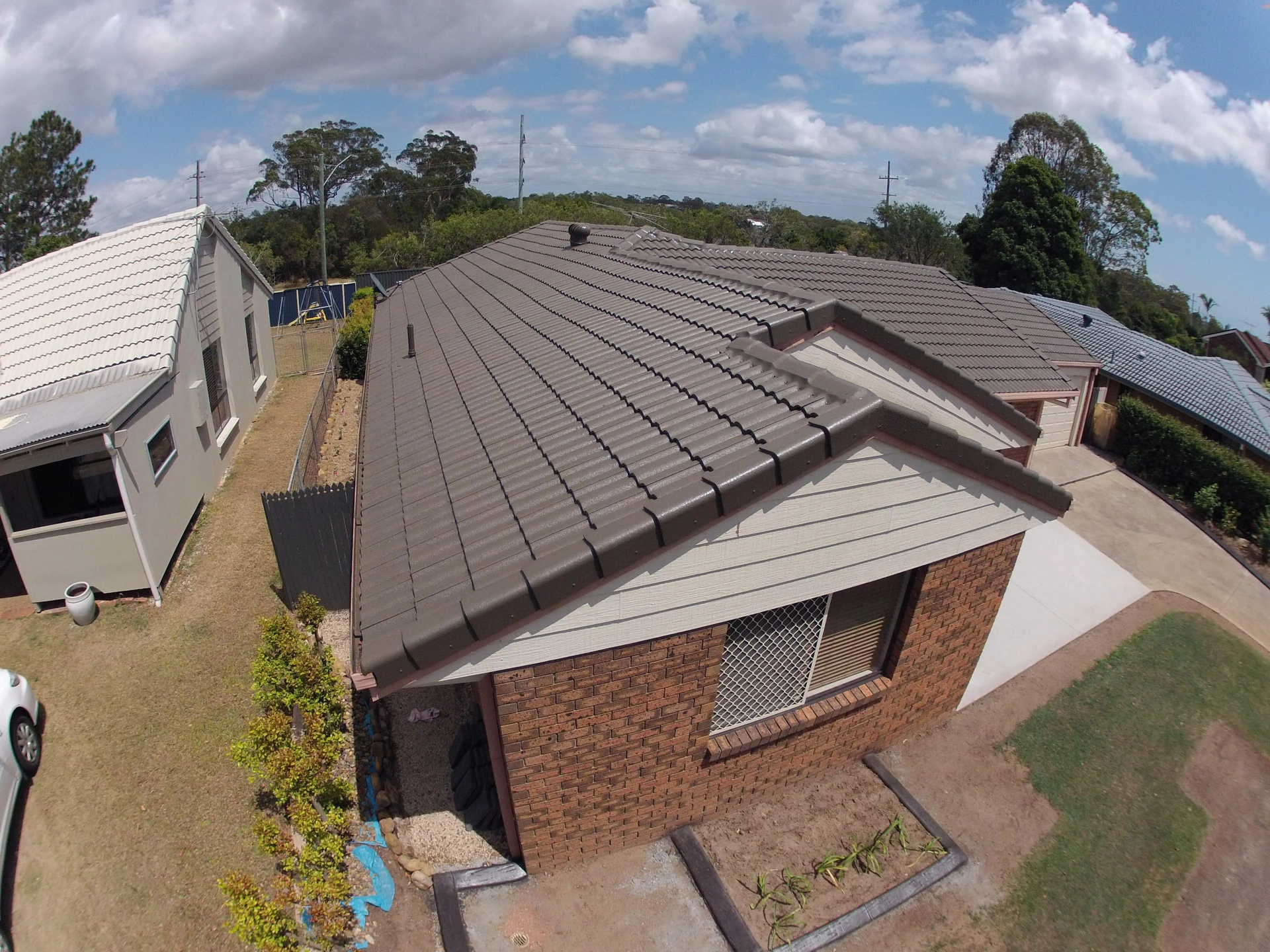 An aerial view of a house with a brown roof