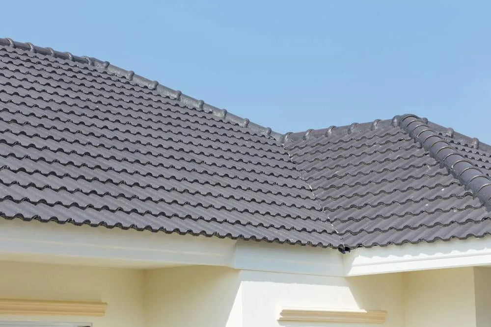 A house with a tiled roof and a blue sky in the background.