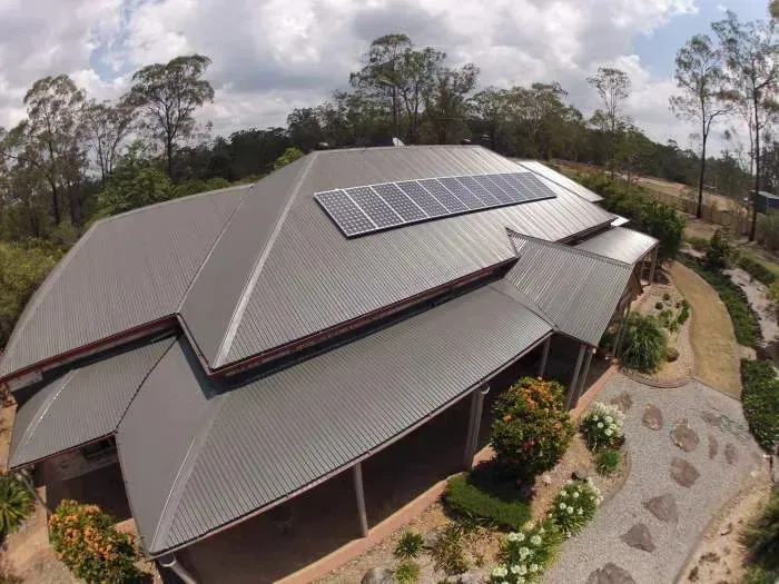An aerial view of a house with solar panels on the roof
