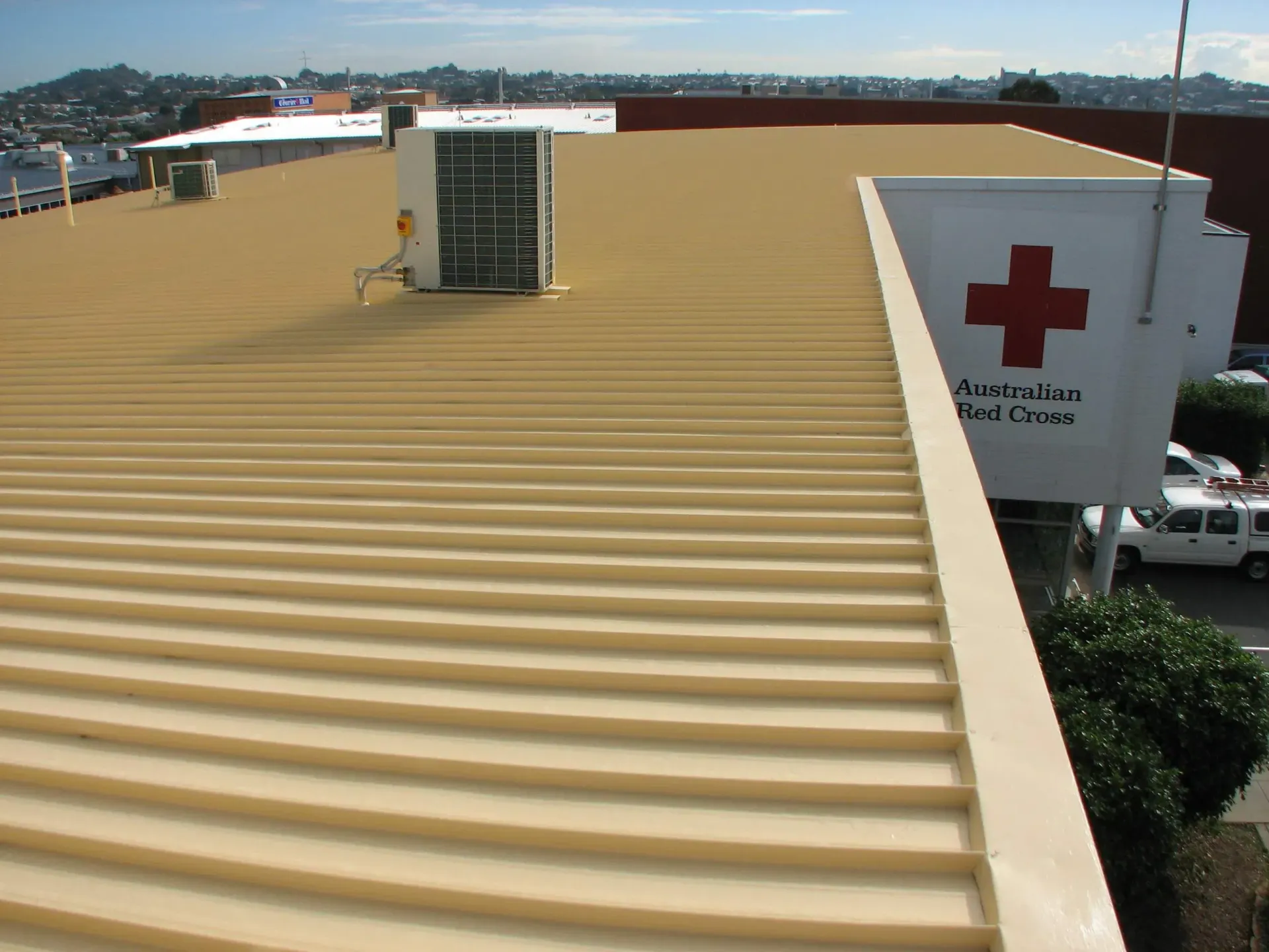 A red cross sign is on the side of a building