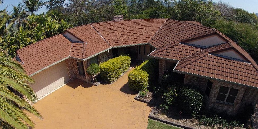 An aerial view of a house with a tiled roof and a driveway.