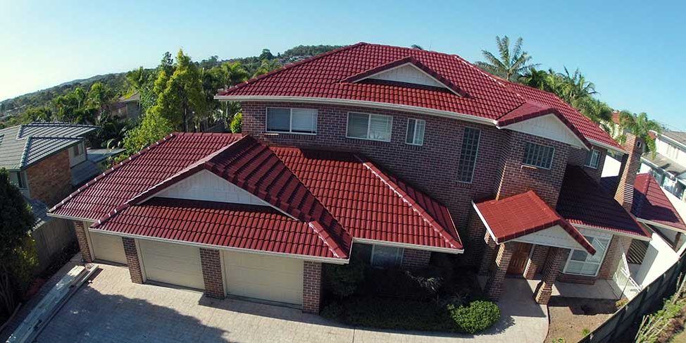 An aerial view of a large house with a red tiled roof.