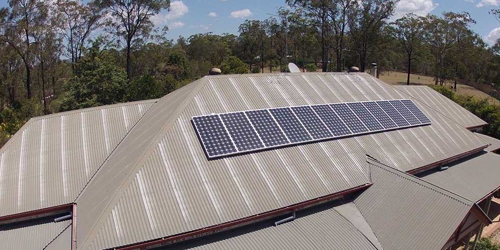 An aerial view of a house with solar panels on the roof.