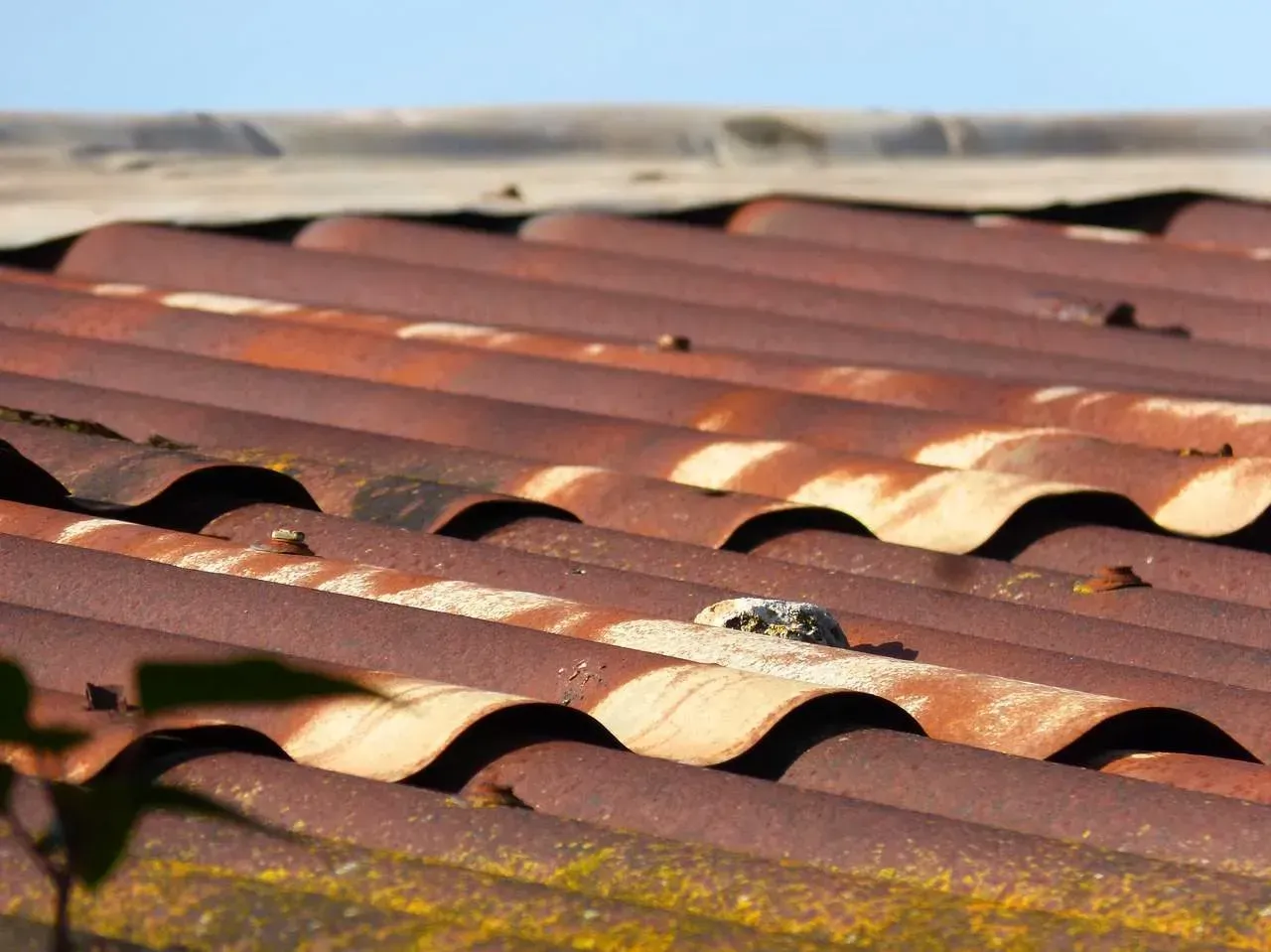 A rusty roof with a blue sky in the background