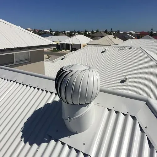 A white roof with a wind turbine on top of it.