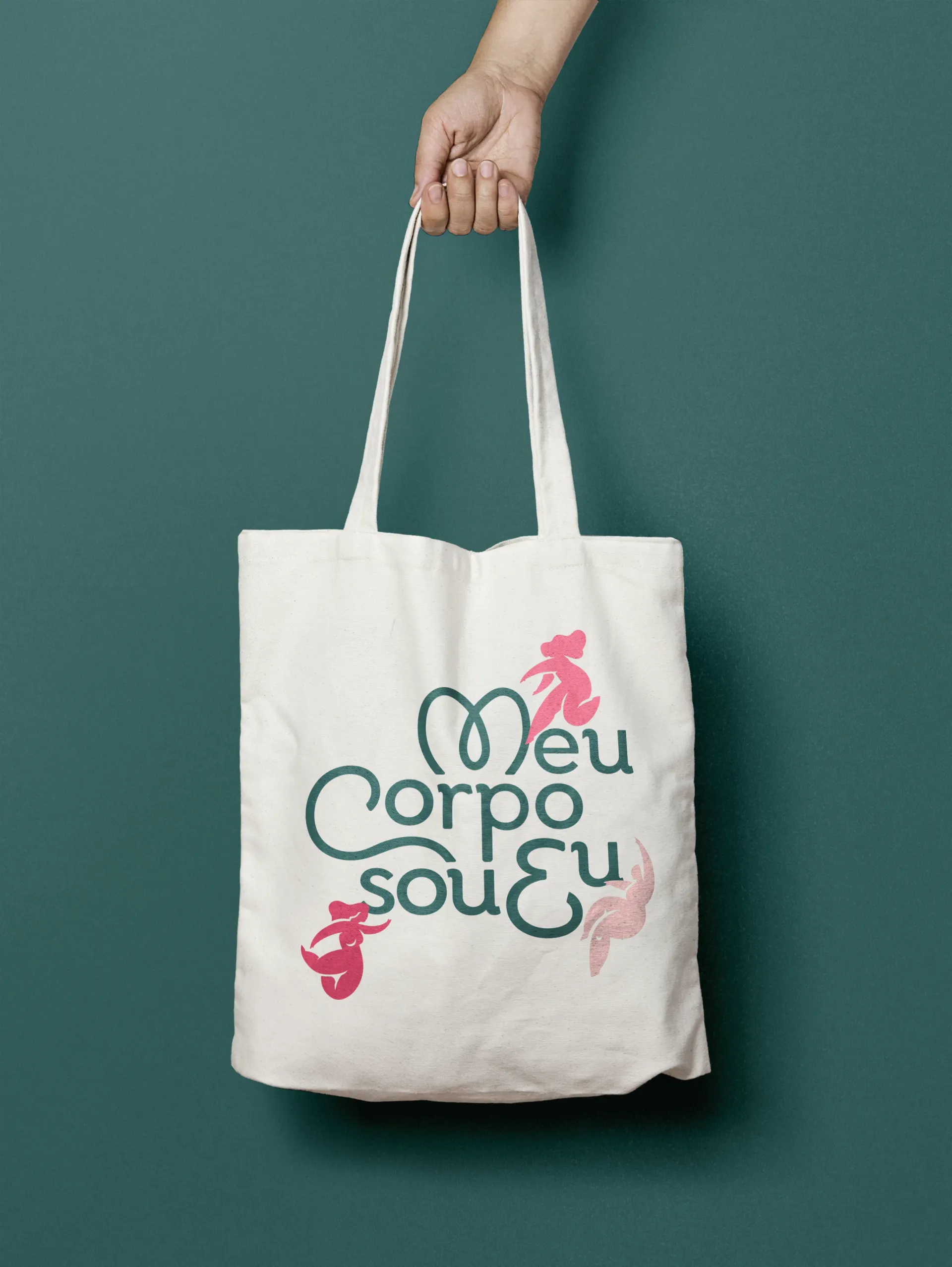 A person is holding a tote bag that says meu corpo sou eu