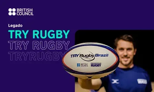 Um homem está segurando uma bola de rugby na mão.