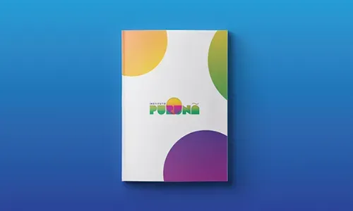 Um livro branco com círculos coloridos está sobre uma superfície azul.