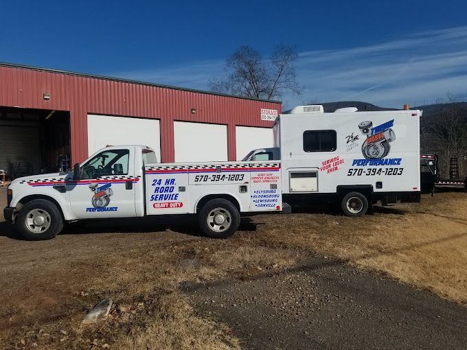 A truck with a trailer attached to it is parked in front of a building.