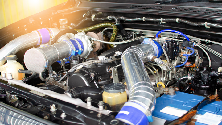 A close up of a car engine with the hood open.