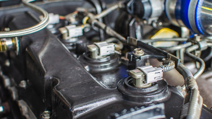 A close up of a car engine with a lot of wires coming out of it.