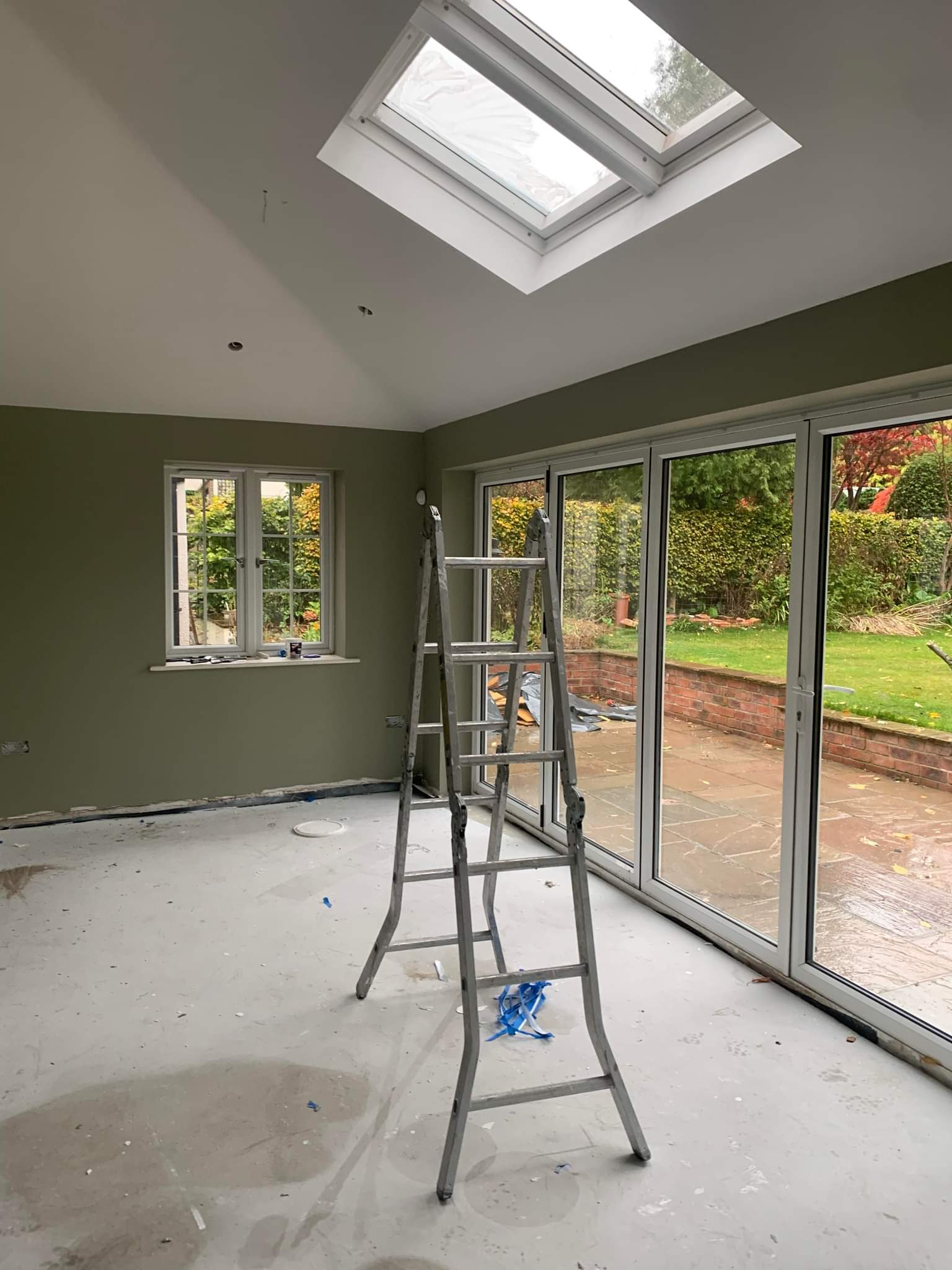 Picture of a kitchen with patio doors painted in sage green by painters and decorators Leeds