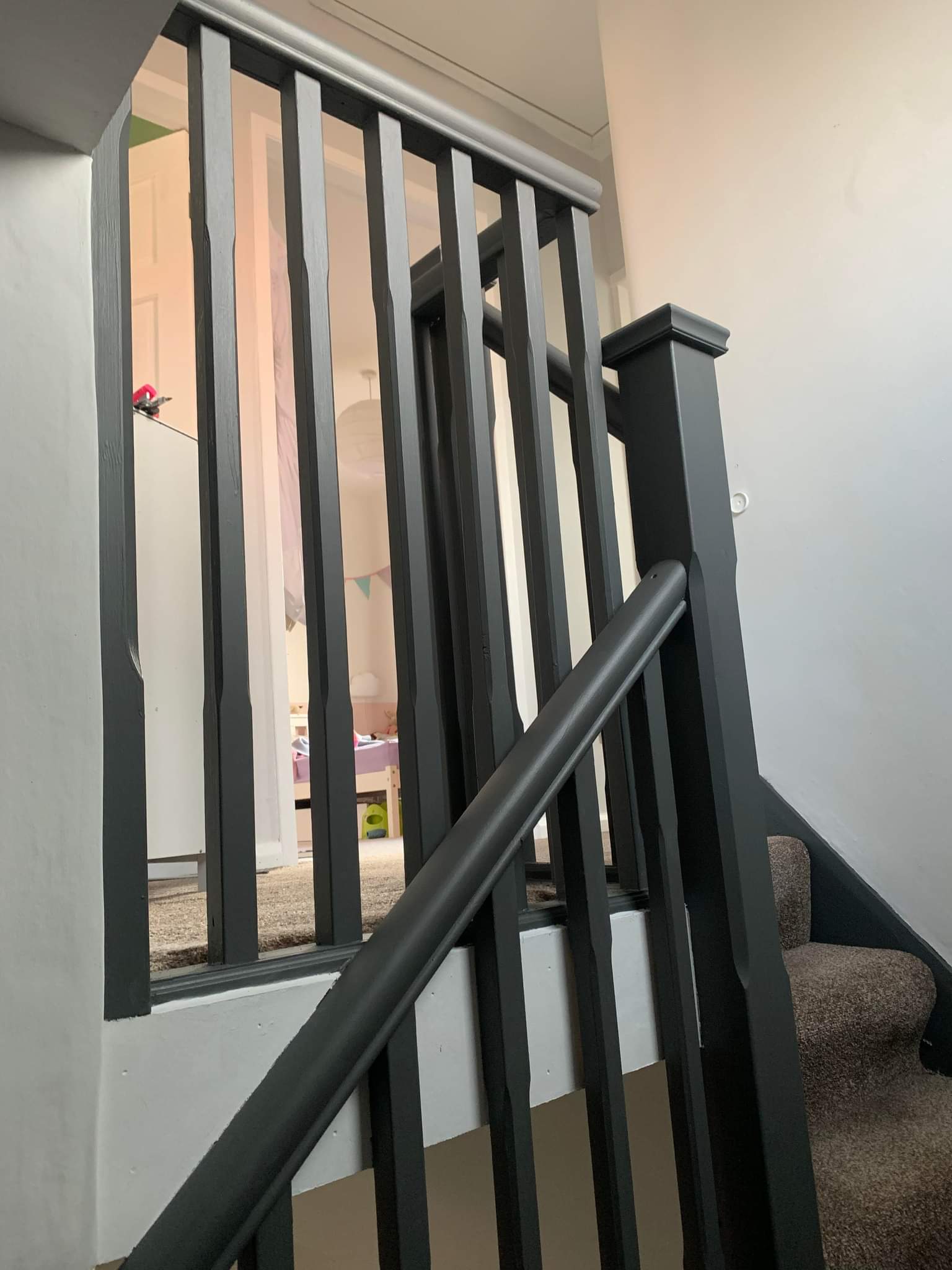 Picture of a landing banister painting in dark grey by painters and decorators Leeds