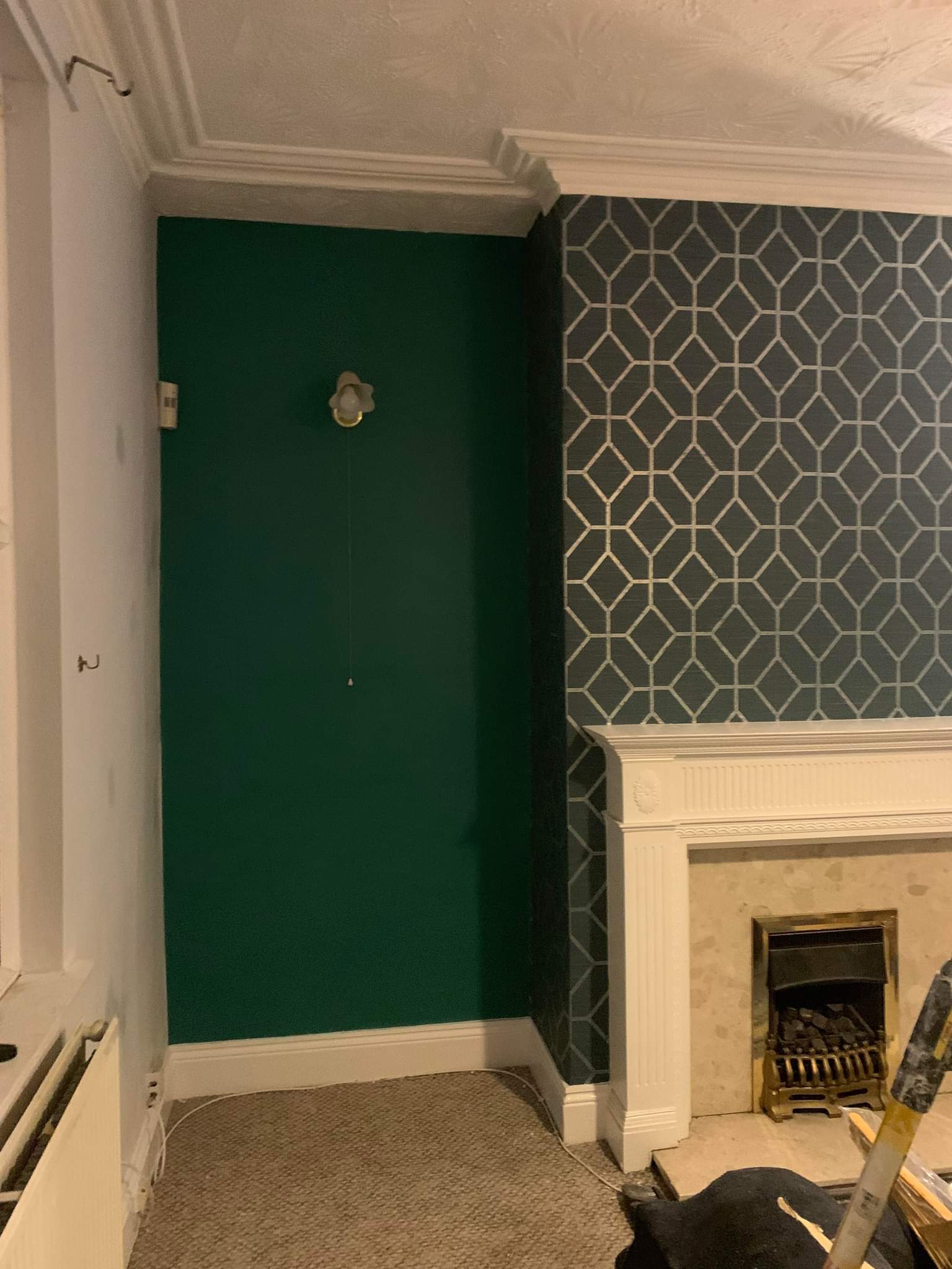 Picture of a living room feature wall with designer wallpaper and green paint surrounding the chimney breast by painters and decorators Leeds