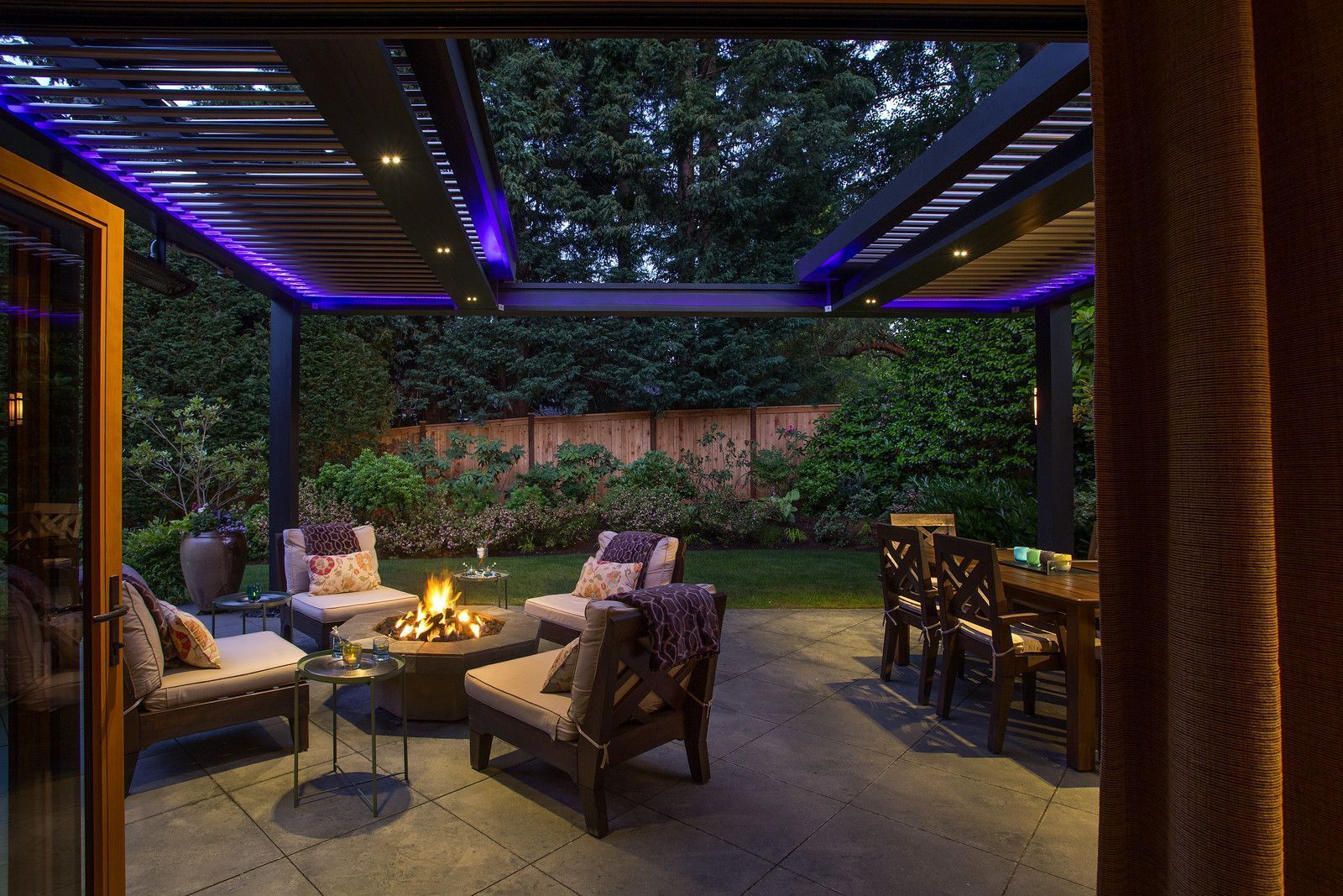 Sleek pergola system providing shade for a restaurant patio with integrated lighting