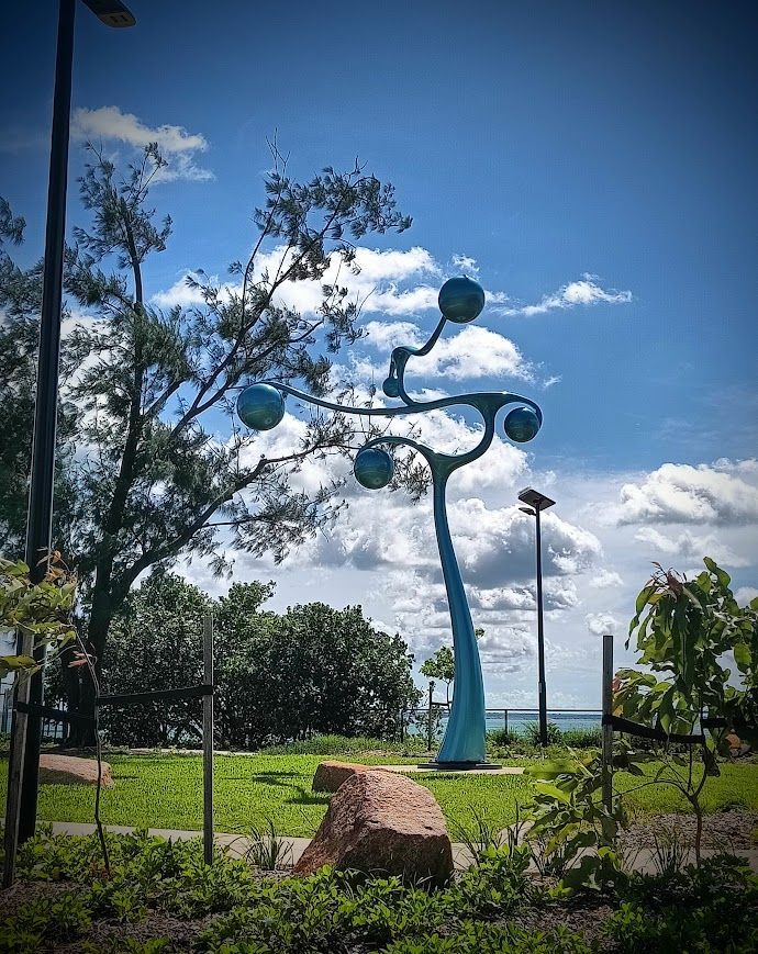 Blue sculpture resembling a tree with spherical orbs in a park, under a cloudy blue sky — NT Driver Guide - Escorted Tours & Transfers in Darwin City, NT