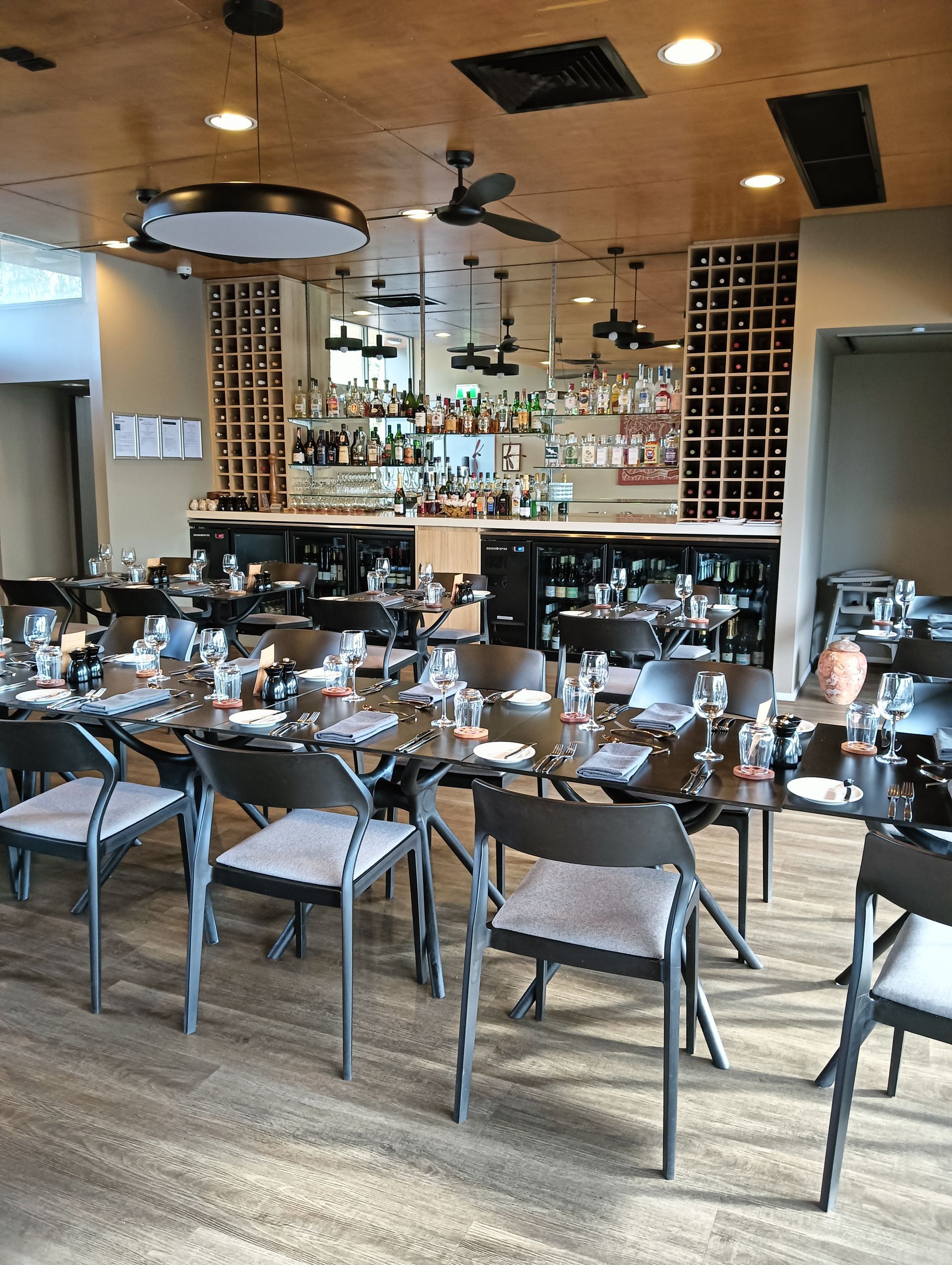 Dining room with tables, chairs, bar in background, wood ceiling, and floor — NT Driver Guide - Escorted Tours & Transfers in Darwin City, NT