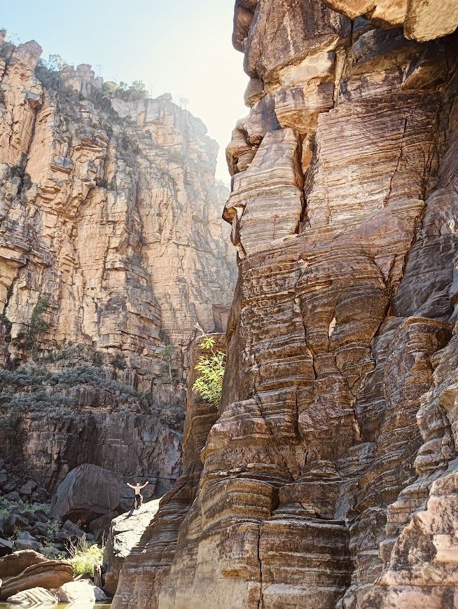 Rocky canyon with layered rock formations, sunlight, and a glimpse of sky — NT Driver Guide - Escorted Tours & Transfers in Darwin City, NT