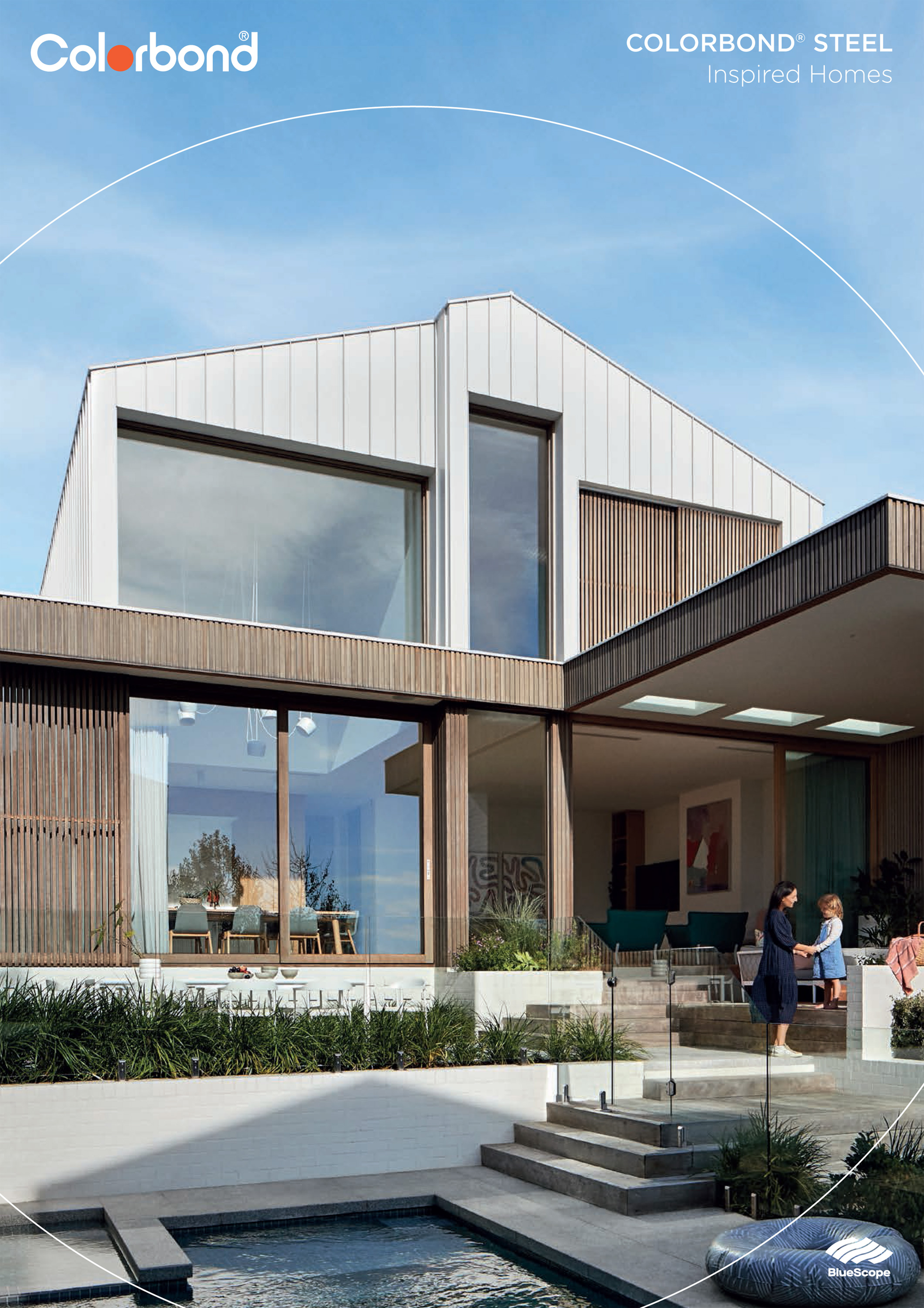 Modern house with light-colored panels, large windows, and a family on the patio. Pool and blue sky visible. Modern house with light-colored panels, large windows, and a family on the patio. Pool and blue sky visible.