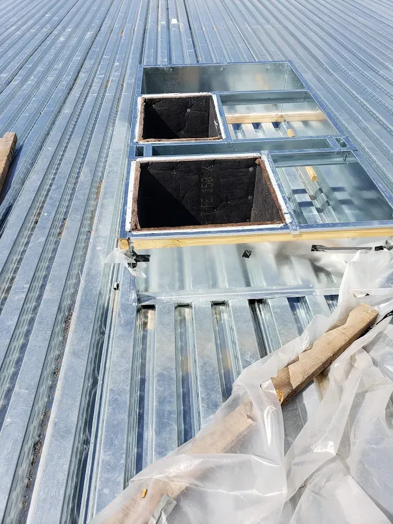 Two rectangular rooftop vents in a metal roof. JL Mechanical - Heating & Cooling