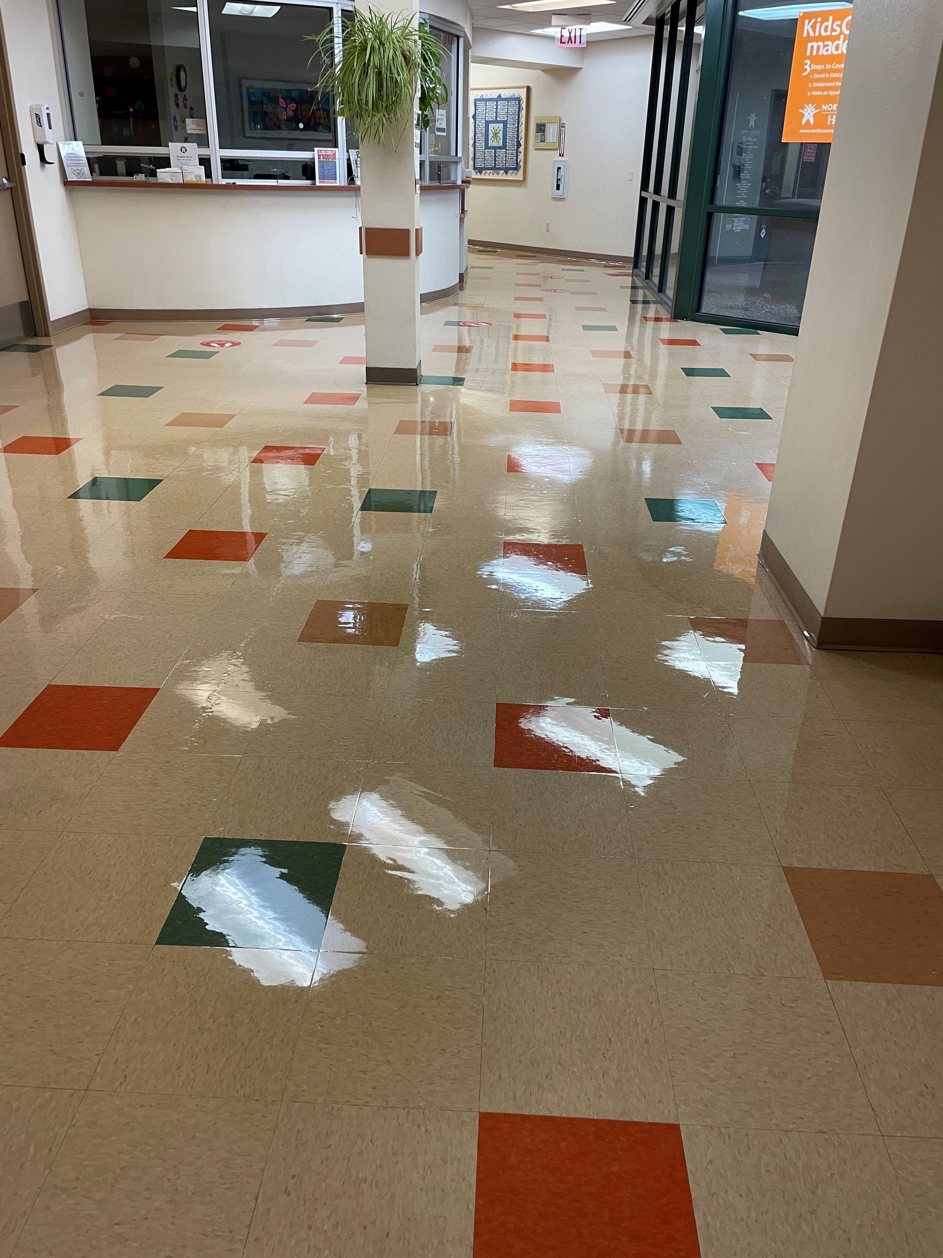 A hallway with a colorful tile floor and a window.