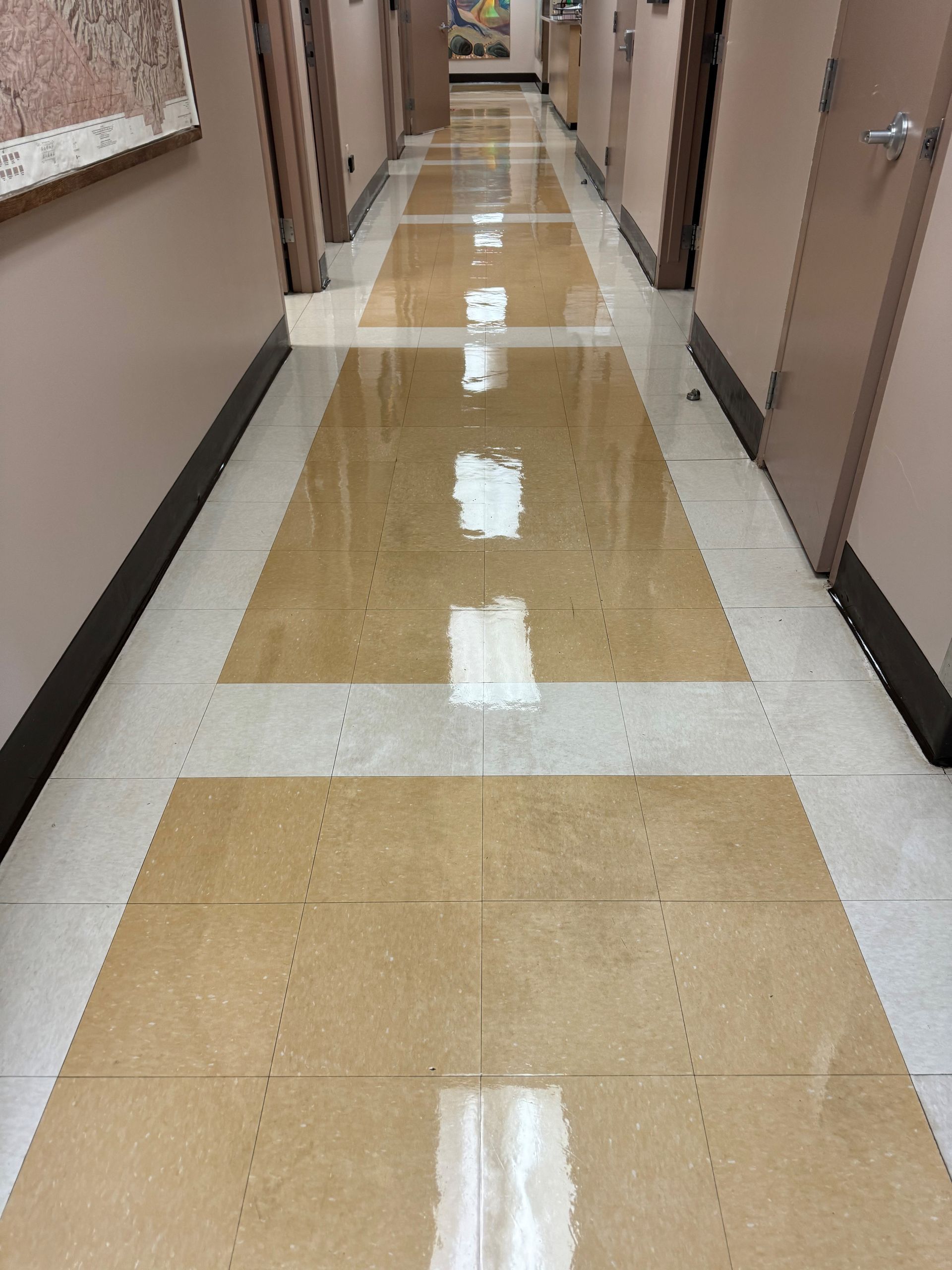 A long hallway in a building with a shiny tile floor.