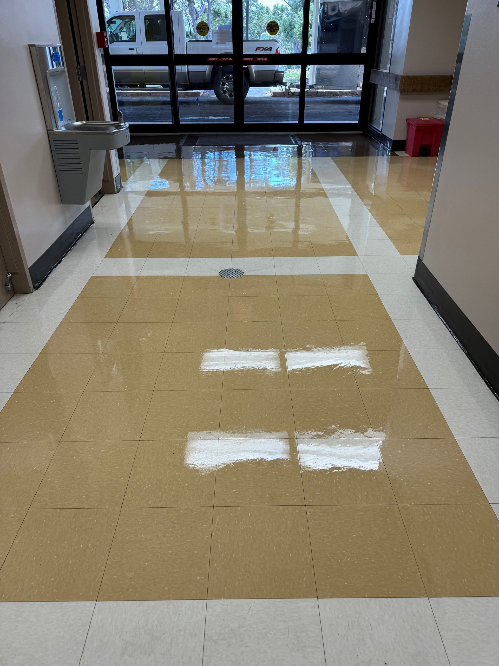 A hallway with a tiled floor and a sink.
