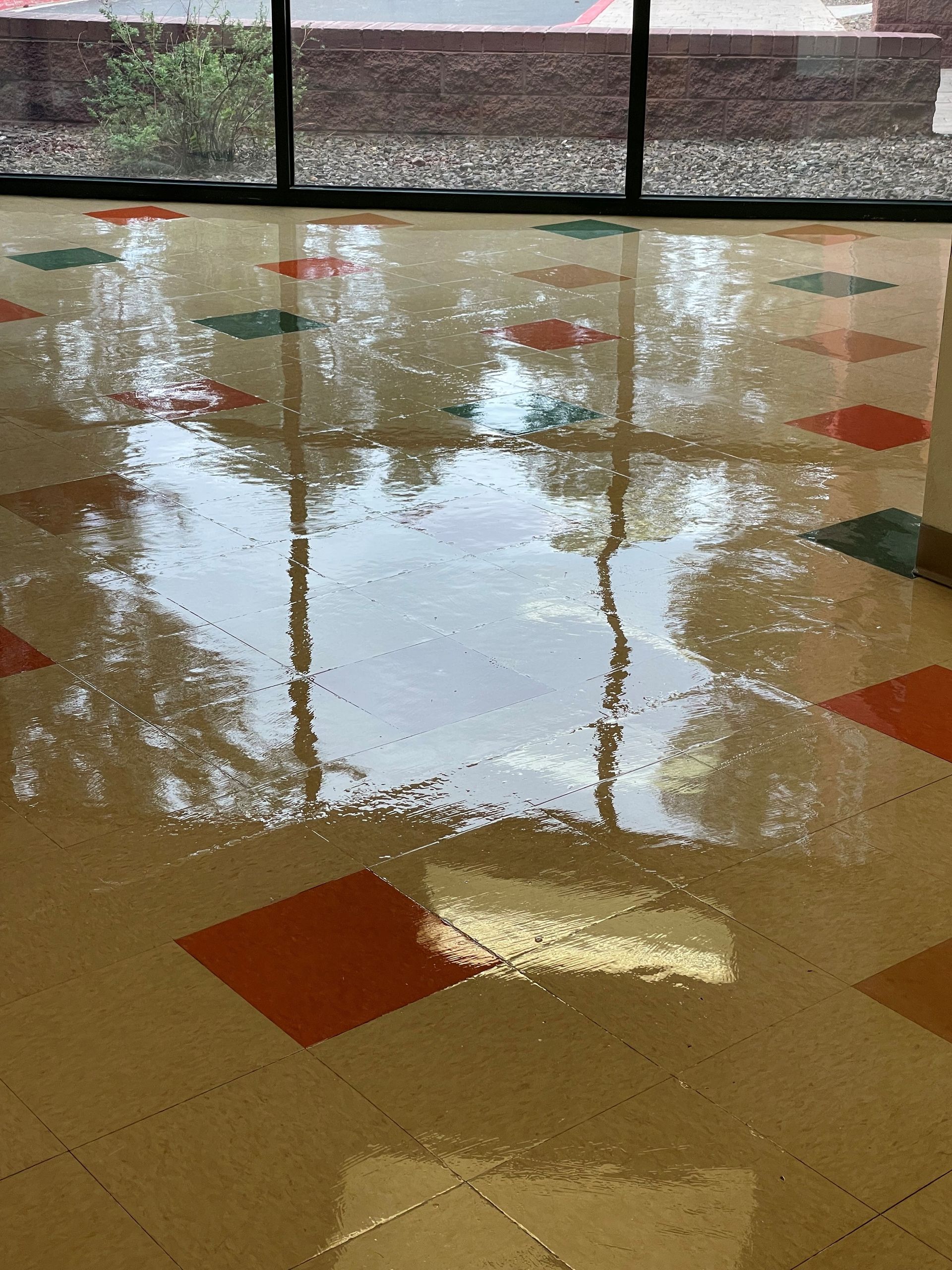 A shiny tiled floor with a window in the background