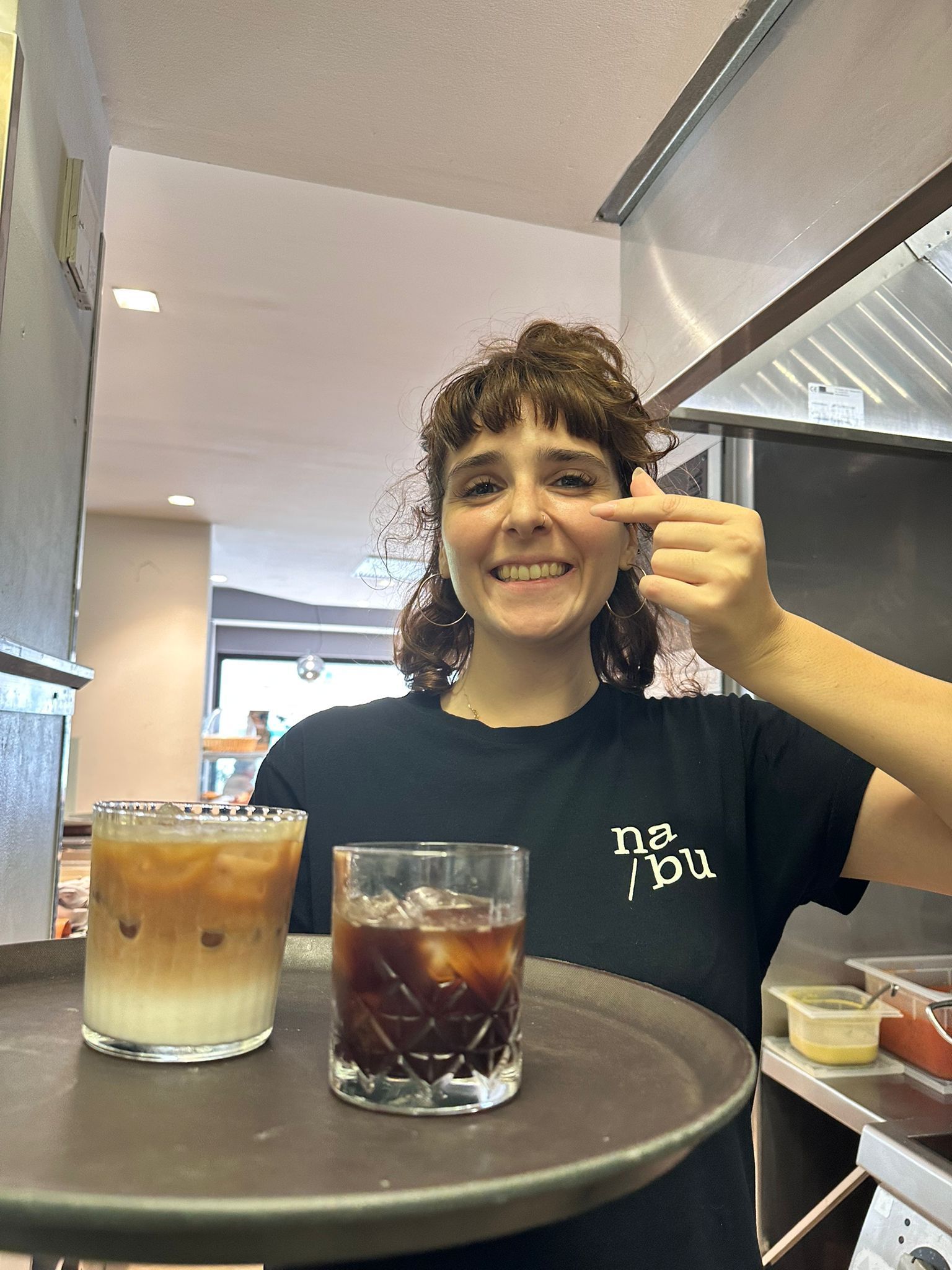 Due mini hamburger su un piatto; ognuno contiene una polpetta fritta, cipolla rossa, pomodoro, lattuga e panino.