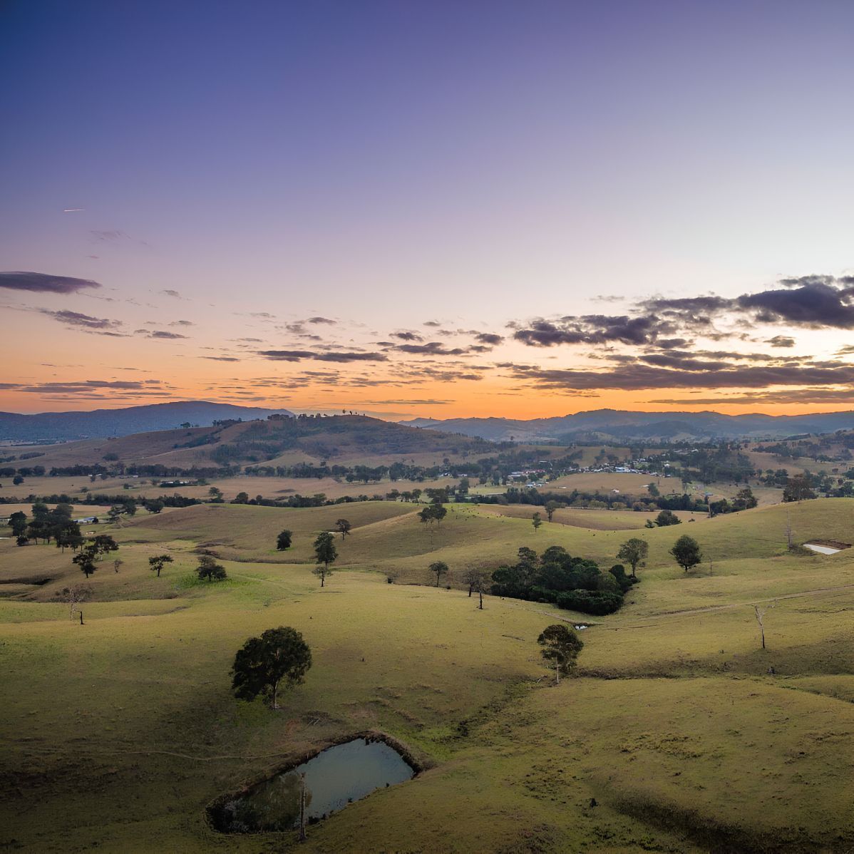 An Aerial View Of A Landscape At Sunset With Mountains In The Background — Master Glass & Glazing In Maitland, NSW