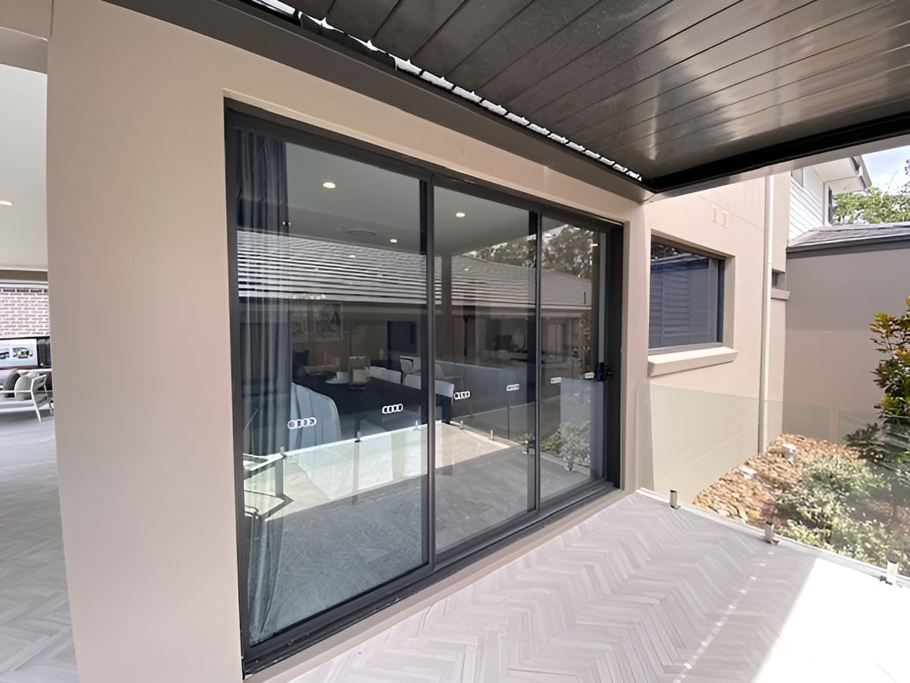 A Sliding Glass Door Is Open To A Patio In A House — Master Glass & Glazing In Eleebana, NSW