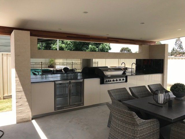 A Kitchen With A Table And Chairs And A Grill — Master Glass & Glazing In Eleebana, NSW