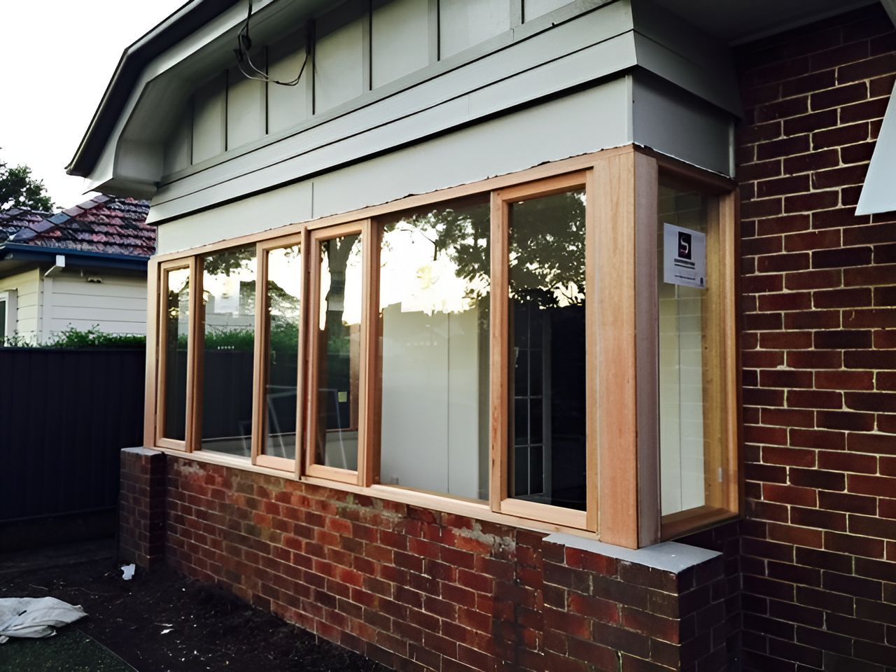 A Brick House With A Large Window On The Side — Master Glass & Glazing In Eleebana, NSW