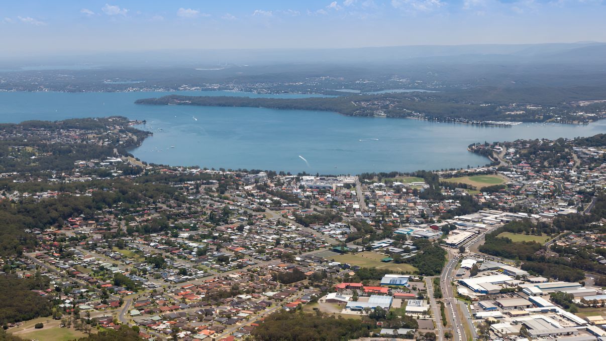 An Aerial View Of A City With A Large Body Of Water In The Background — Master Glass & Glazing In Warners Bay, NSW