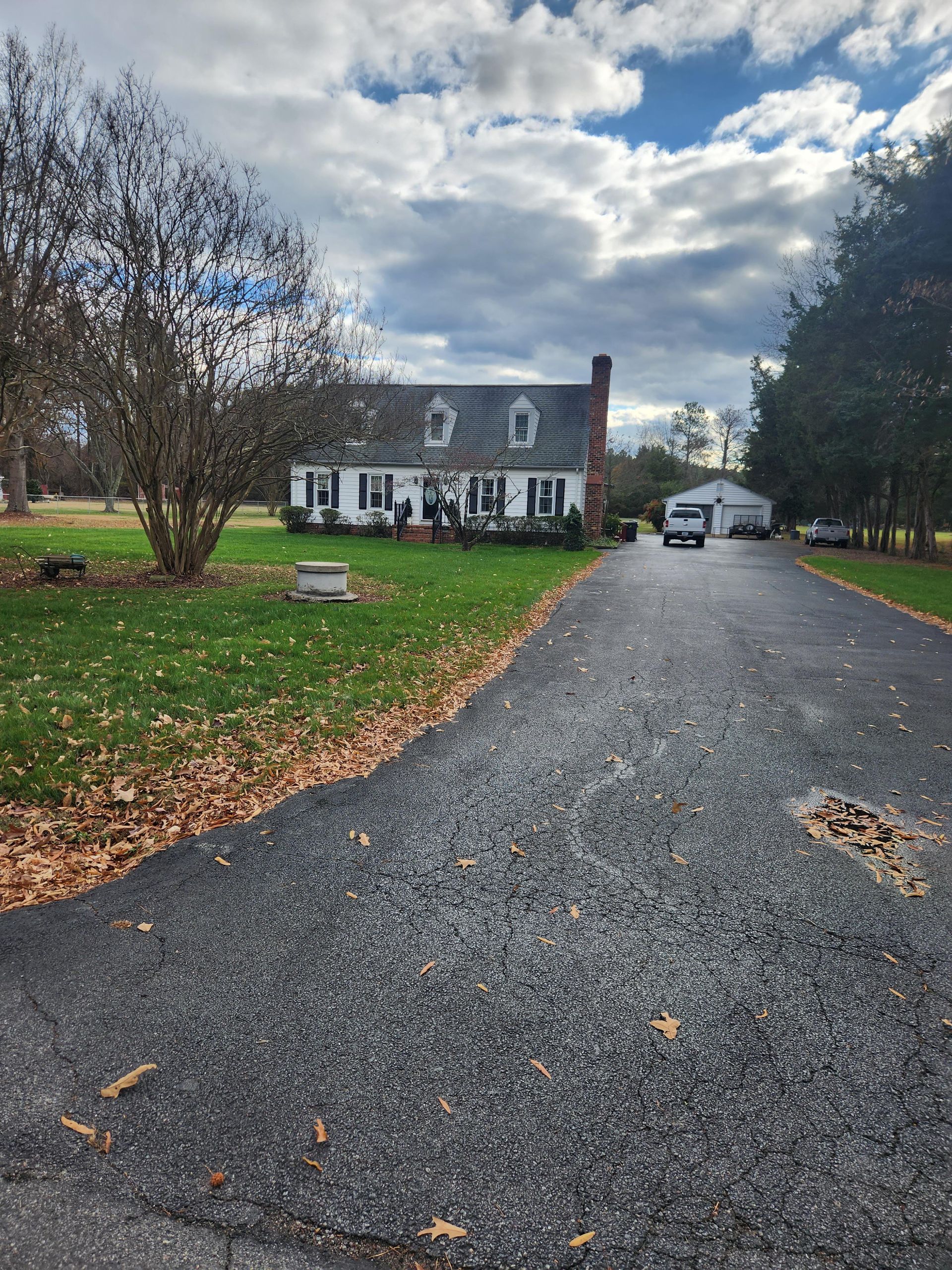 A driveway leading to a large white house