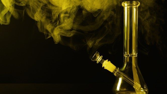 A yellow gassy smoke floating over a yellow glass bong.