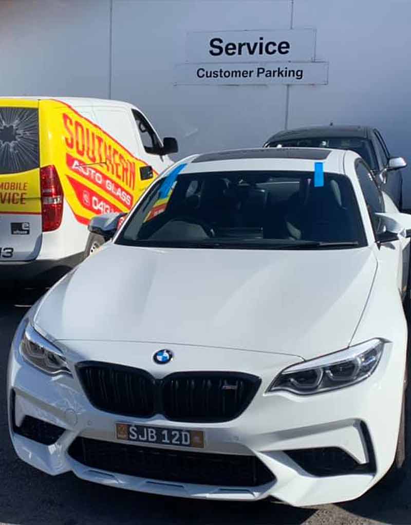 a white BMW with a recently replaced windscreen