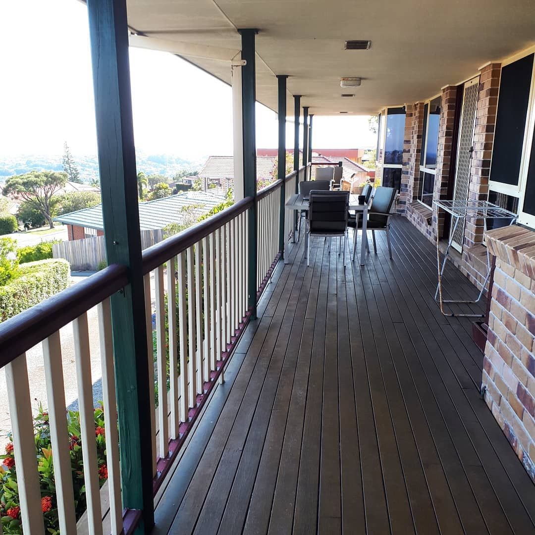 A Balcony With A Railing And A Table And Chairs On It — Pottsville Carpentry and Home Maintenance In Pottsville, NSW