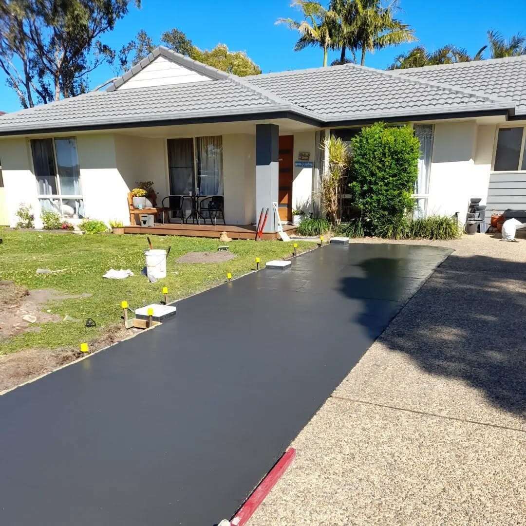 A White House With A Black Driveway In Front Of It — Pottsville Carpentry and Home Maintenance In Pottsville, NSW