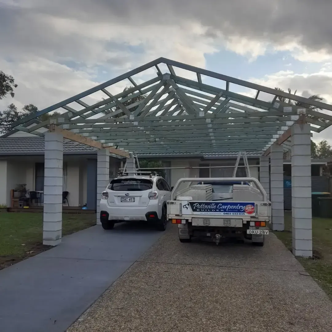 Two Cars Are Parked Under A Carport In Front Of A House — Pottsville Carpentry and Home Maintenance In Pottsville, NSW