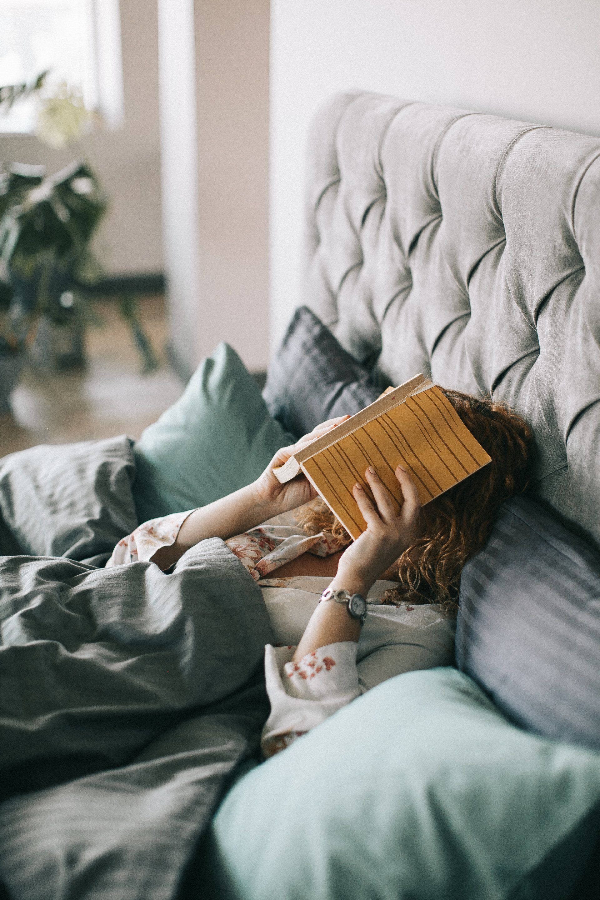 Woman Reading Book on Bed