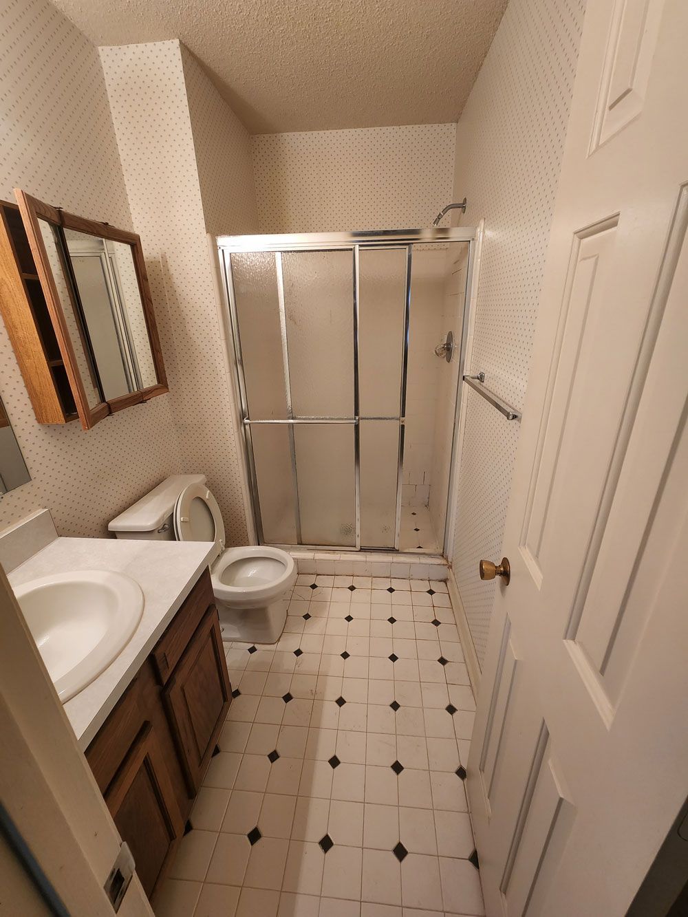 A bathroom with a toilet a sink and a shower