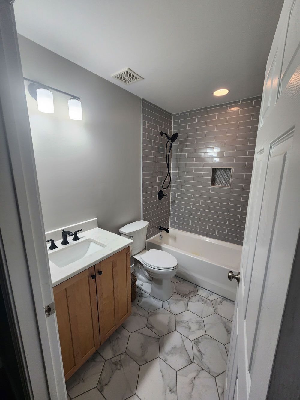 A bathroom with a sink , toilet , tub and shower.