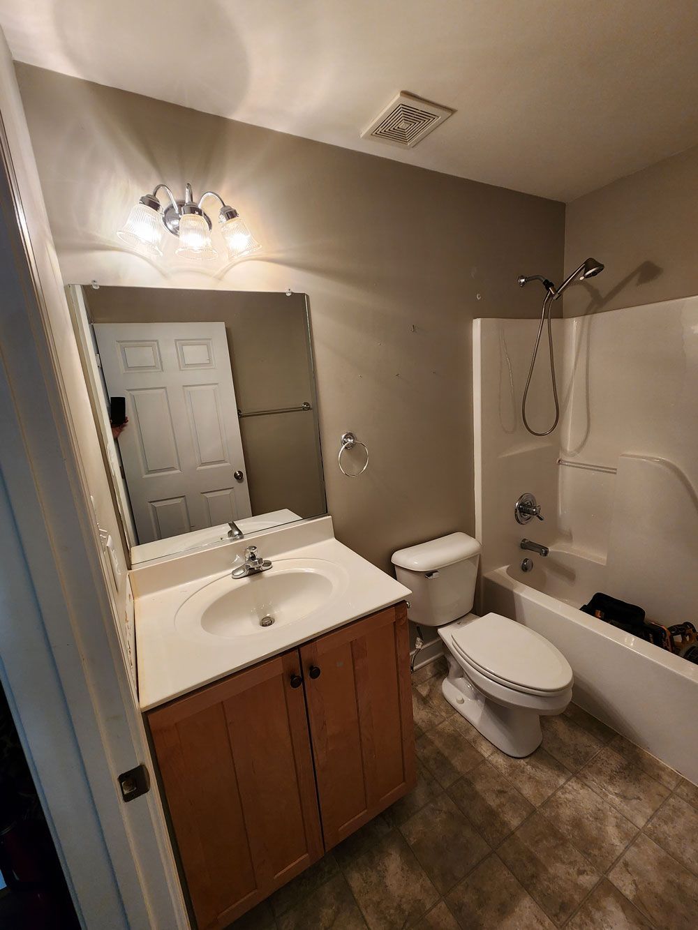 A bathroom with a sink , toilet , bathtub and mirror.