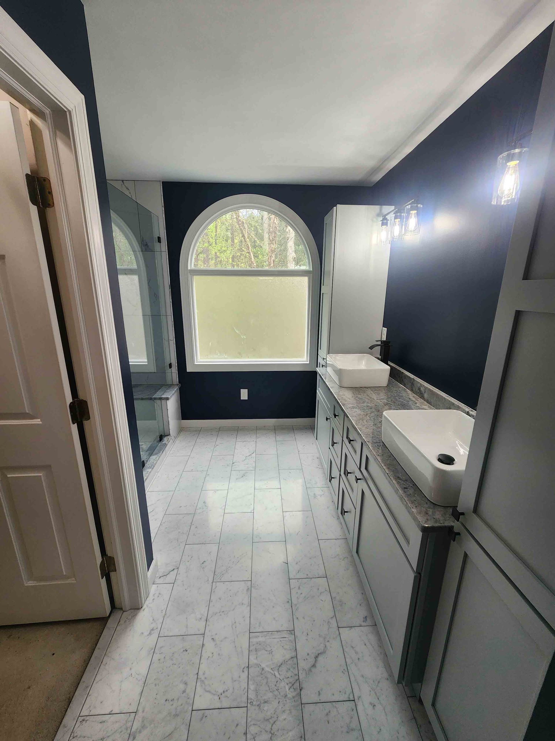 A kitchen with stainless steel appliances and white cabinets.
