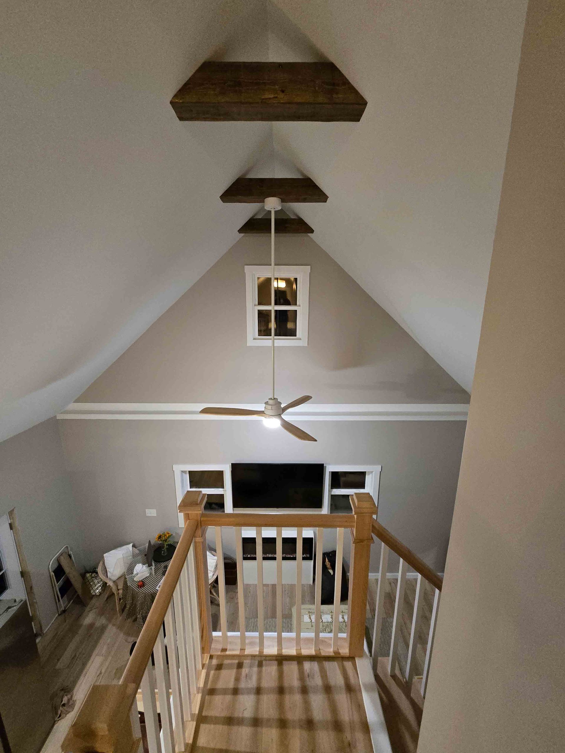 A ceiling fan is hanging from the ceiling of a living room.